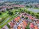 Overhead view capturing houses nestled beside a golf course, complete with winding waterways and serene ponds at 903 Santa Anna Ln, Lady Lake, FL 32159