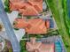 Aerial view of terracotta-roofed houses featuring pools, screened patios, and lush landscaping at 903 Santa Anna Ln, Lady Lake, FL 32159
