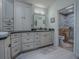 Bathroom featuring vanity, framed mirror, wood-look flooring, and tiled shower stall with glass door at 903 Santa Anna Ln, Lady Lake, FL 32159