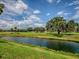 Scenic view of a golf course and pond, with lush greenery and clear blue skies at 903 Santa Anna Ln, Lady Lake, FL 32159