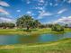 Picturesque view of golf course and pond, showcasing beautiful green landscapes and clear blue sky at 903 Santa Anna Ln, Lady Lake, FL 32159