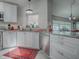 Modern kitchen with stainless steel dishwasher, white cabinets, granite countertops and tile backsplash at 903 Santa Anna Ln, Lady Lake, FL 32159