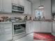 Well-lit kitchen featuring stainless steel appliances, granite countertops, and white cabinetry at 903 Santa Anna Ln, Lady Lake, FL 32159