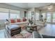 Bright living room with large windows, comfortable seating, wooden floors, and a stylish area rug at 903 Santa Anna Ln, Lady Lake, FL 32159