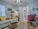 Cozy living room with plush white sofa, patterned ottoman, vintage rug and a home office area at 903 Santa Anna Ln, Lady Lake, FL 32159