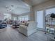 Open-concept living room with vaulted ceilings, wood floors, and access to the patio, creating a bright and airy space at 903 Santa Anna Ln, Lady Lake, FL 32159