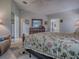 Bright main bedroom featuring floral bedding, light gray walls, ceiling fan and wood floors at 903 Santa Anna Ln, Lady Lake, FL 32159