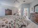Comfortable main bedroom with floral bedding, gray walls, wood floors and a ceiling fan at 903 Santa Anna Ln, Lady Lake, FL 32159