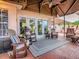 Relaxing covered patio with comfortable rocking chairs, a cozy rug, and views of the backyard at 903 Santa Anna Ln, Lady Lake, FL 32159