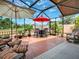 Outdoor patio with comfortable seating, umbrellas, and views of the lush landscaped yard and golf course at 903 Santa Anna Ln, Lady Lake, FL 32159