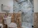 Close up of tiled shower featuring decorative glass door, tile walls, a showerhead and a toilet at 903 Santa Anna Ln, Lady Lake, FL 32159