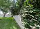 Backyard featuring a white vinyl fence, manicured lawn, and mature trees and shrubs at 9375 Woodbreeze Blvd, Windermere, FL 34786