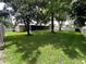 Spacious backyard featuring a well-kept lawn, mature trees, and a white vinyl fence at 9375 Woodbreeze Blvd, Windermere, FL 34786