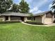 Charming single-story home with manicured lawn, mature trees and attached two car garage at 9375 Woodbreeze Blvd, Windermere, FL 34786