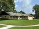 Charming single-story home with a lush, green lawn and mature trees at 9375 Woodbreeze Blvd, Windermere, FL 34786