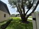 Landscaped front yard with mature trees, green lawn, and a glimpse of neighborhood street at 9375 Woodbreeze Blvd, Windermere, FL 34786