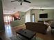 Open living room featuring hardwood floors, ceiling fans, and seamless access to the kitchen at 9375 Woodbreeze Blvd, Windermere, FL 34786