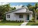 Charming single-story home featuring a covered porch, a blue front door, and tropical landscaping at 9878 Peebles St, Orlando, FL 32827