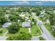Aerial view showcases the property and neighborhood with a pool, green lawns, mature trees, and street access at 1 W Pierce Ave, Orlando, FL 32809