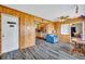 Spacious living room featuring knotty pine walls and trim with laminate flooring, flowing into the adjacent kitchen area at 1 W Pierce Ave, Orlando, FL 32809