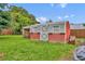 Red and gray shed in the backyard with windows and door, providing practical storage at 1 W Pierce Ave, Orlando, FL 32809