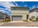 Two-story home featuring a gray garage door, yellow exterior, and a manicured front yard at 10061 Dulbecco St, Orlando, FL 32827