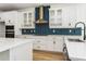 Stunning kitchen with white cabinetry, contrasting hardware, and stainless appliances complemented by trendy backsplash details at 10061 Dulbecco St, Orlando, FL 32827
