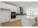 Stylish kitchen featuring sleek white cabinets, stainless appliances, and a modern backsplash, perfect for culinary enthusiasts at 10061 Dulbecco St, Orlando, FL 32827