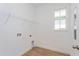 Well-lit laundry room with wood-look flooring, shelving, and utility hookups at 10061 Dulbecco St, Orlando, FL 32827