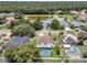 Suburban homes with backyard pools set against a backdrop of lush greenery and a lake at 1109 Needlewood Loop, Oviedo, FL 32765