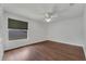 Bedroom features hardwood floors, a ceiling fan, and a large window at 1109 Needlewood Loop, Oviedo, FL 32765