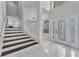 Bright foyer showcases tiled flooring, a decorative front door, and a staircase to the second floor at 1109 Needlewood Loop, Oviedo, FL 32765