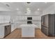 Updated kitchen with stainless steel appliances, granite countertops, center island, and tile flooring at 1109 Needlewood Loop, Oviedo, FL 32765