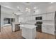 Stylish kitchen with white cabinets, granite countertops, center island and modern stainless steel appliances at 1109 Needlewood Loop, Oviedo, FL 32765