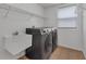 Functional laundry room with modern washer and dryer, sink, and storage shelving for convenience at 1109 Needlewood Loop, Oviedo, FL 32765