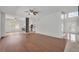 Open living room with hardwood floors and a view into the kitchen with white cabinetry at 1109 Needlewood Loop, Oviedo, FL 32765