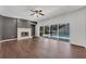 Spacious living room featuring a brick fireplace, ceiling fan and sliding glass doors leading to the pool area at 1109 Needlewood Loop, Oviedo, FL 32765