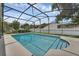 Backyard swimming pool with covered enclosure, basketball hoop, and landscaped surroundings at 1109 Needlewood Loop, Oviedo, FL 32765