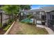 Spacious backyard with screen-enclosed patio and a pathway at 1130 Woodsong Way, Clermont, FL 34714