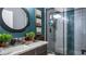 Bathroom featuring decorative round mirror, shower, and plants at 1130 Woodsong Way, Clermont, FL 34714