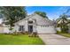 Charming single Gathering home with a well-manicured lawn, vibrant landscaping, and a two car garage at 1130 Woodsong Way, Clermont, FL 34714
