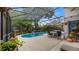 A relaxing screened-in pool with a table, chairs and an umbrella for your enjoyment at 1130 Woodsong Way, Clermont, FL 34714