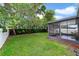 Lush backyard with green lawn and a screened-in porch, perfect for outdoor relaxation and entertaining at 15169 Harrowgate Way, Winter Garden, FL 34787