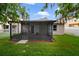Screened-in patio surrounded by green grass and white fence offering a cozy outdoor retreat at 15169 Harrowgate Way, Winter Garden, FL 34787