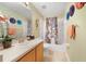 Bright bathroom features an extended vanity and a shower with a colorful curtain at 15169 Harrowgate Way, Winter Garden, FL 34787