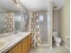 Bathroom featuring a vanity with double sinks, tile flooring, and a shower stall enclosed with a floral shower curtain at 15169 Harrowgate Way, Winter Garden, FL 34787