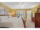 Bright bedroom featuring carpet flooring, a wood bed frame, and a window with shutter style blinds at 15169 Harrowgate Way, Winter Garden, FL 34787