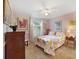 Cozy bedroom with pink walls, floral bedding, and a window with shutters at 15169 Harrowgate Way, Winter Garden, FL 34787