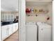 Laundry room with white washer and dryer adjacent to the kitchen area at 15169 Harrowgate Way, Winter Garden, FL 34787