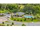 Aerial view highlighting the community pool, amenity center, parking, and surrounding lush greenery at 15954 Winding Bluff Dr, Montverde, FL 34756